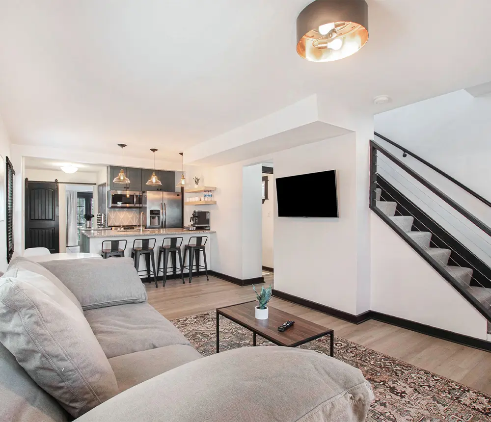 Spacious basement boasting a modern kitchen setup against pristine white walls. The expansive area offers ample room for culinary adventures and entertaining guests. The clean white walls enhance the sense of openness and brightness, creating a welcoming atmosphere for gatherings and relaxation in this versatile living space.