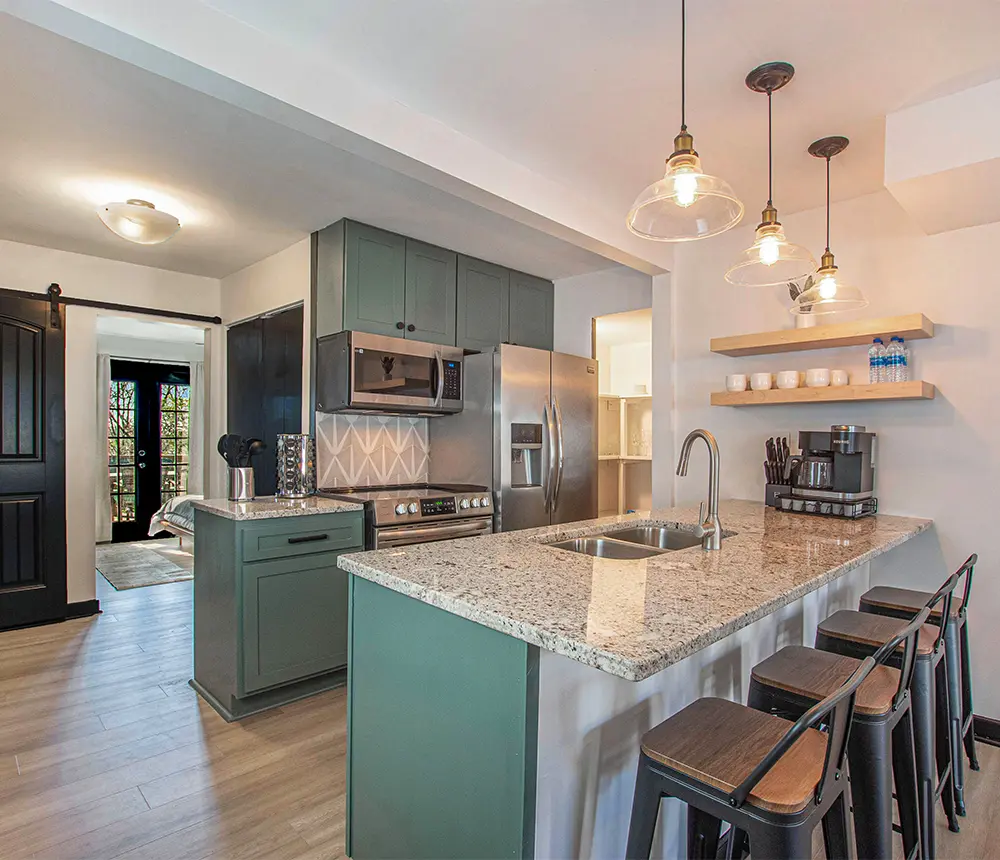 A kitchen space with green cabinets remodeled by Rise Up Renovations