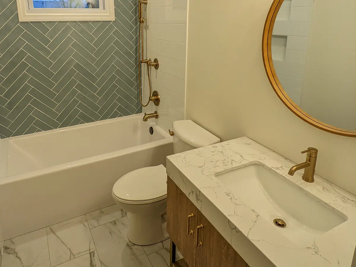 tile floor in a bathroom with a simple vanity and golden fixtures