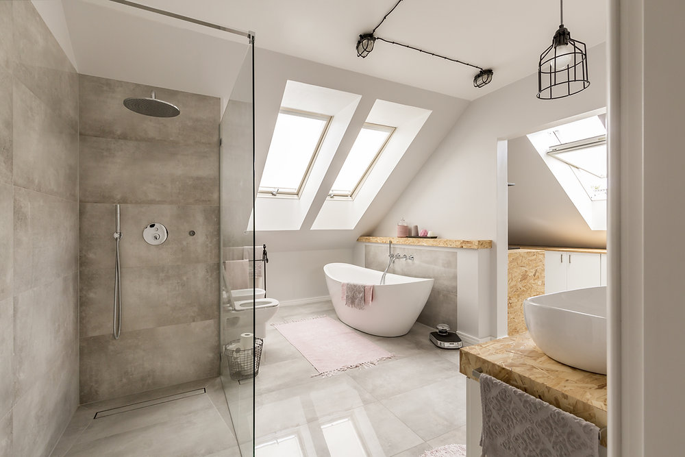 Modern bathroom interior showcasing a sleek walk-in shower with a clear glass enclosure and a rain showerhead, alongside a stylish free-standing tub with a wall-mounted faucet, all complemented by large high-gloss floor tiles.