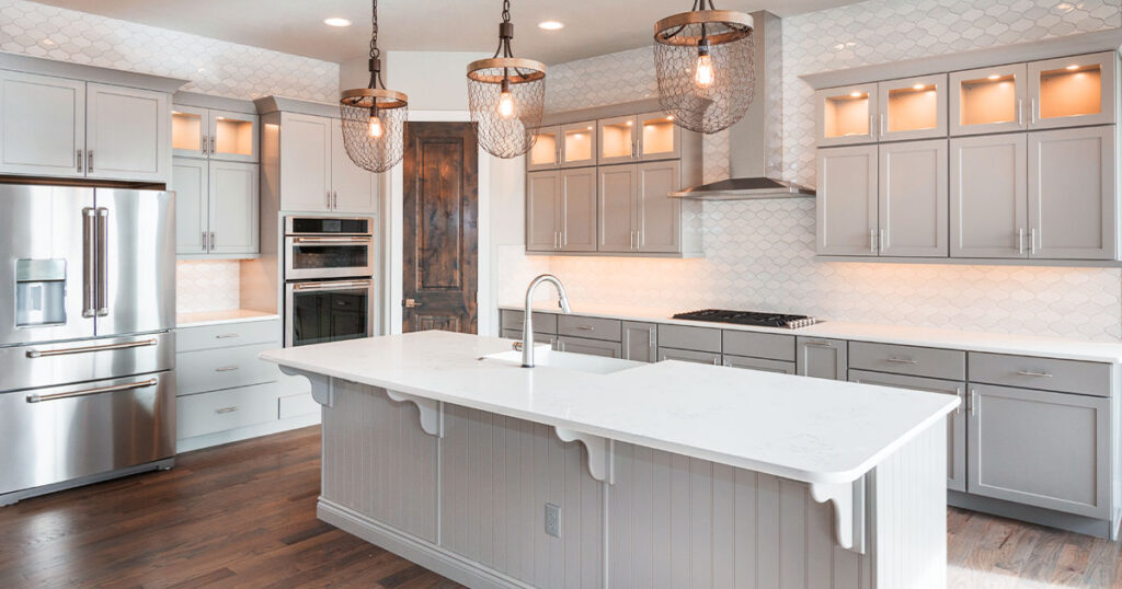 Modern kitchen with gray cabinets, large island, and pendant lighting