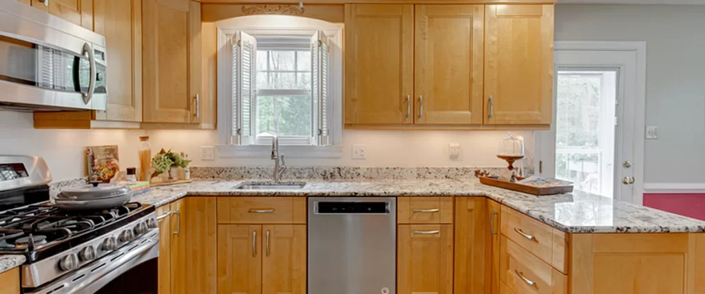 kitchen with light wood cabinets, granite countertops, and stainless steel appliances